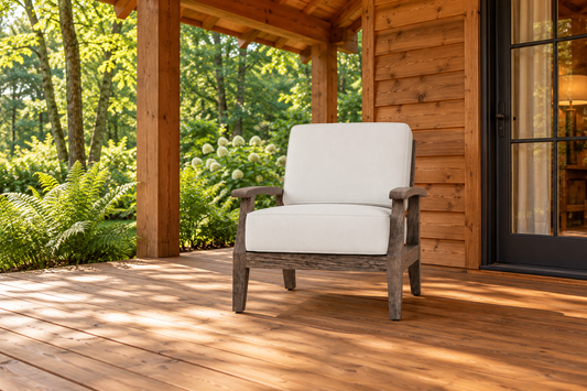Lloyd Flanders Frontier Lounge Chair, sold individually, in an AI-styled cedar cabin porch setting with a wood deck and leafy garden.