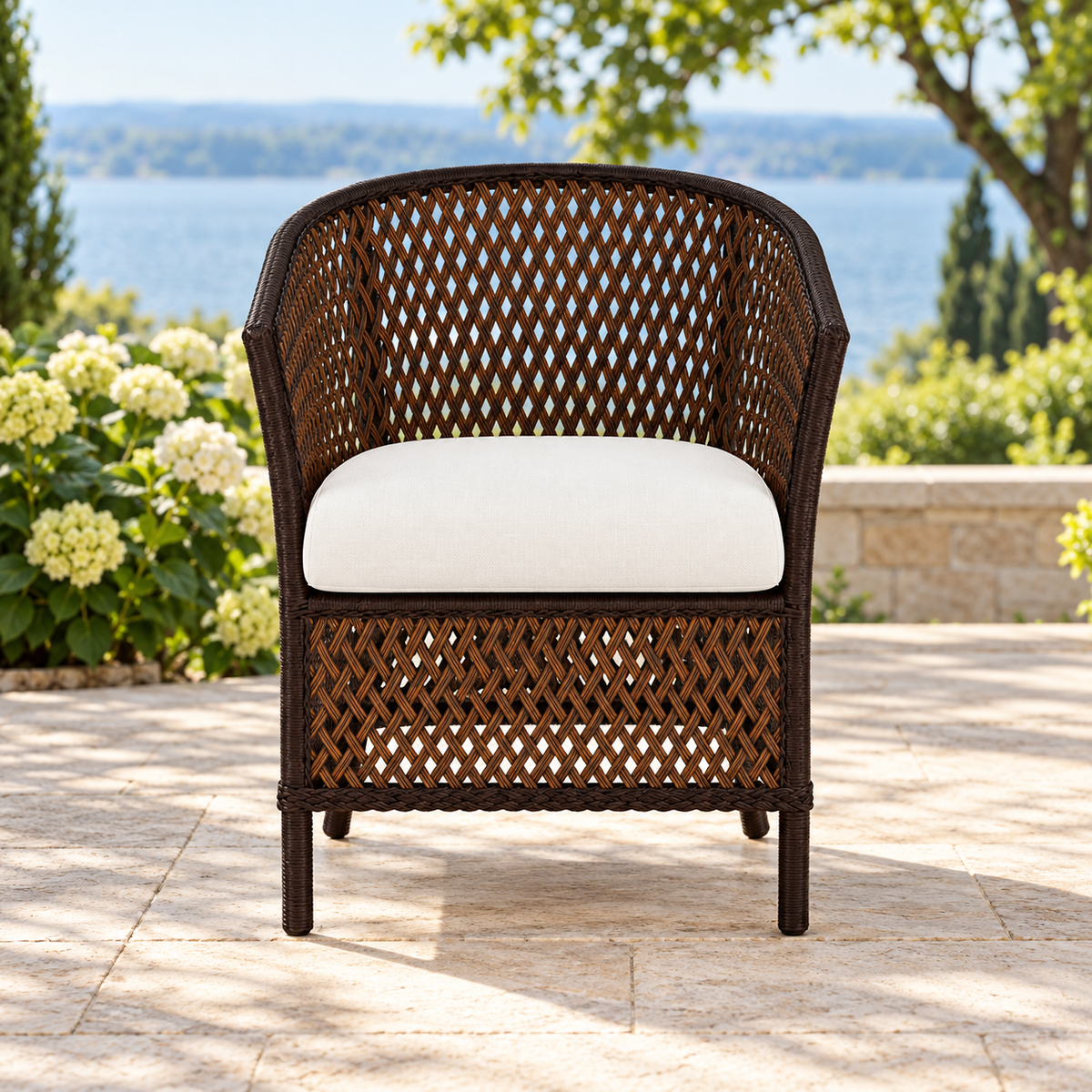 Lloyd Flanders Grand Traverse Barrel Dining Chair on a lakeside garden terrace