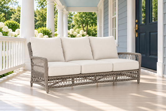 Lloyd Flanders Mackinac Sofa, sold individually, in an AI-styled luxurious front-porch setting.